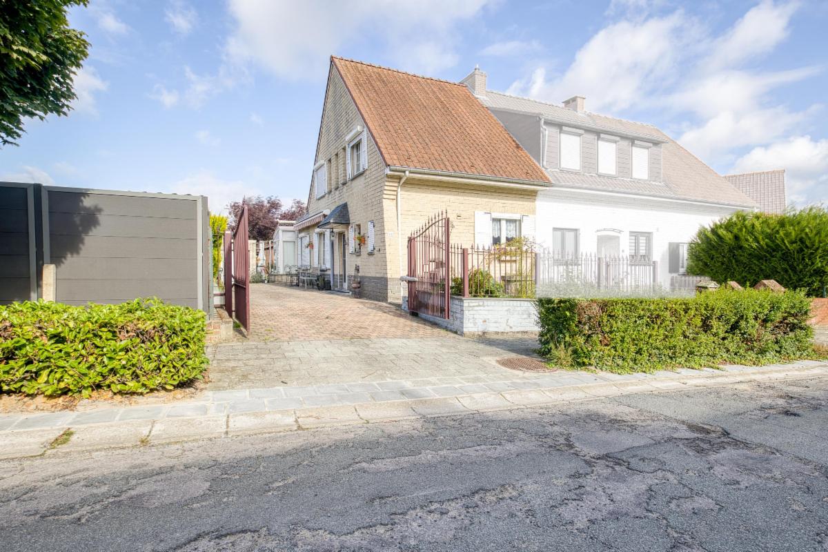 Maison 3 façades avec jardin et garage.